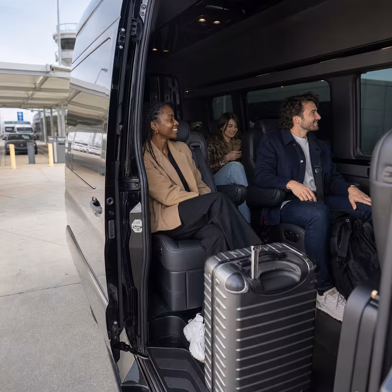 Passengers loading luggage while boarding an Lexington group shuttle