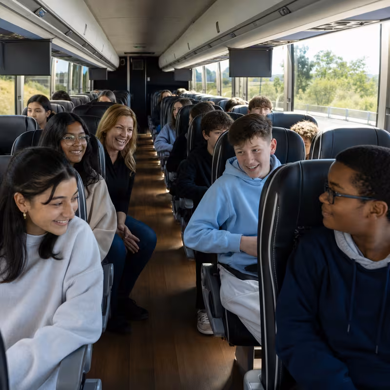 Group boarding a white charter bus for School Transportation transportation in Lexington