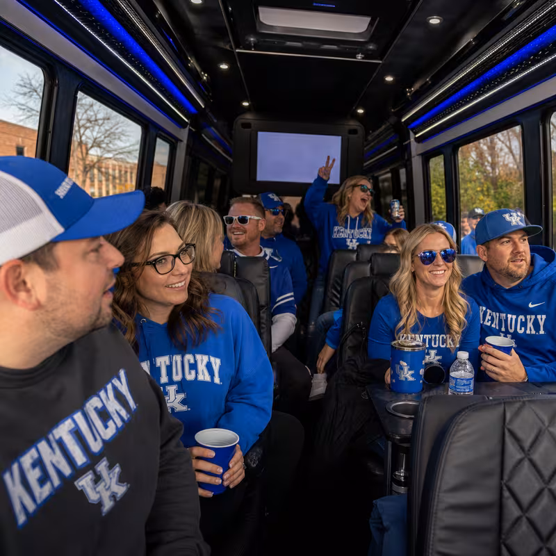 Group boarding a white charter bus for Sporting Event Transportation transportation in Lexington